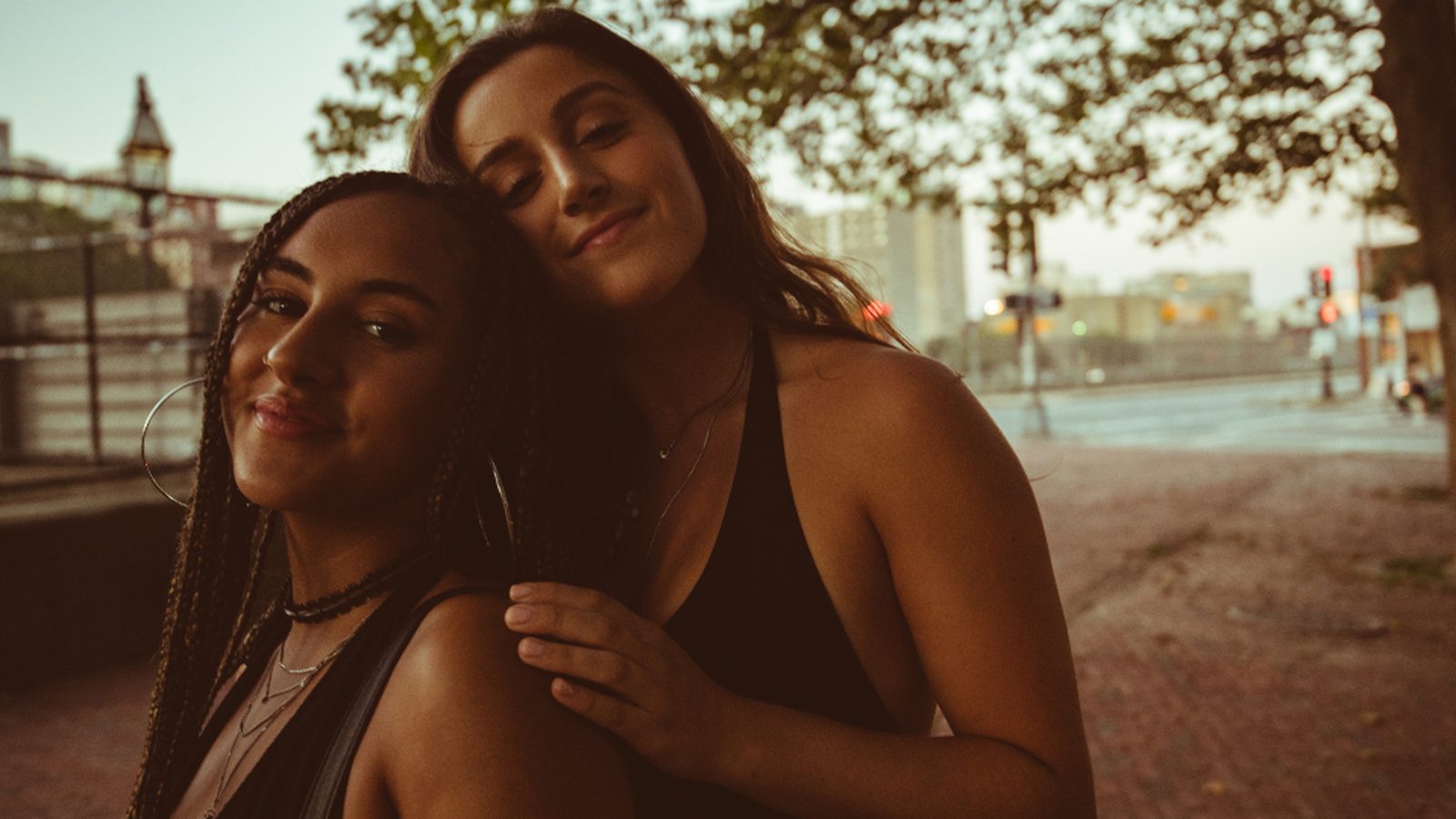 Two friends leaning on each other at golden hour
